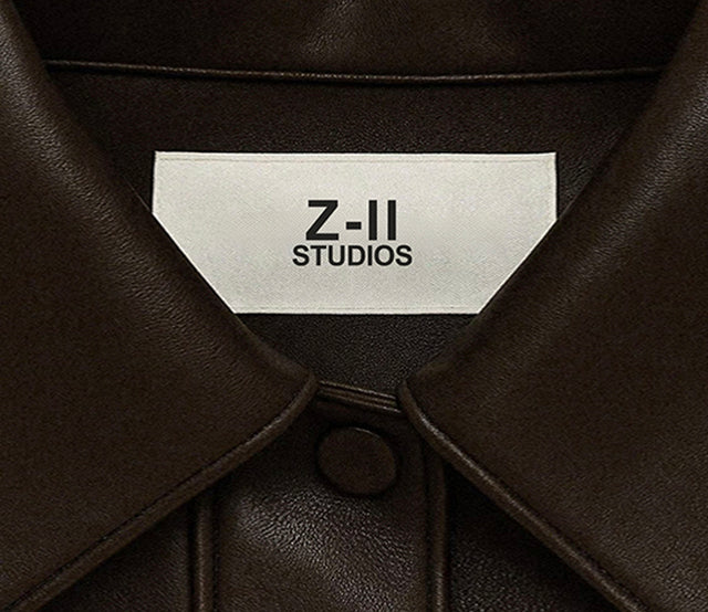 Close-up of a brown leather jacket with a 'Z-II STUDIOS' label.