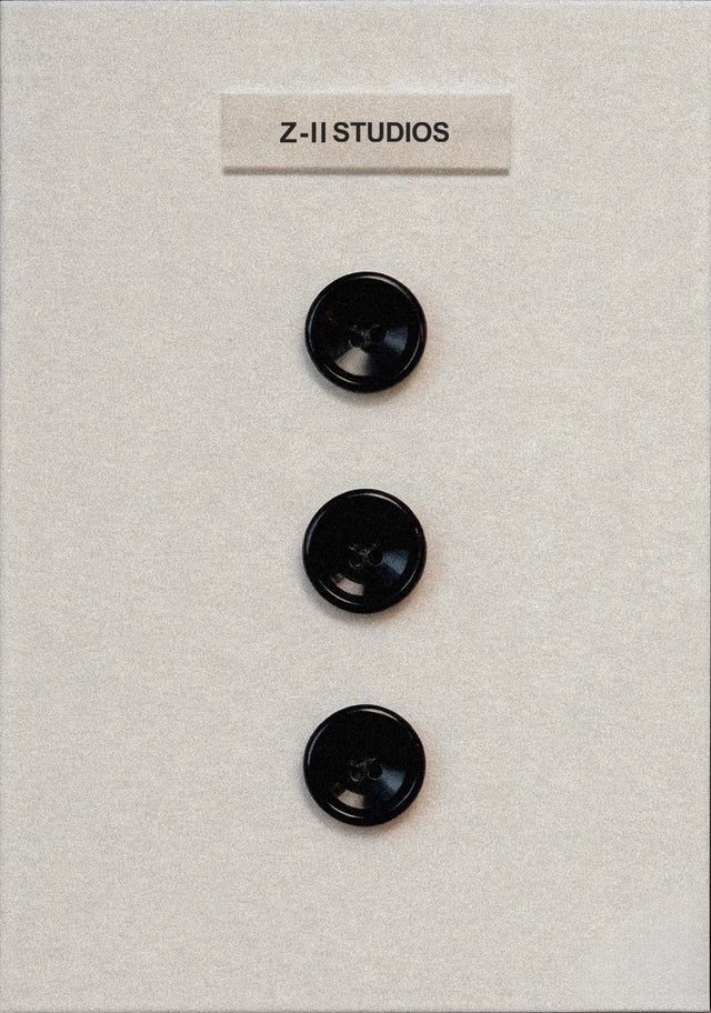 Three black buttons on a textured beige background with 'Z-II STUDIOS' label.